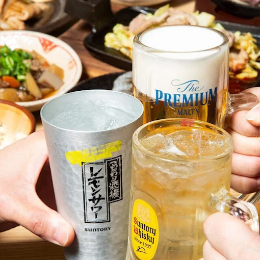 冷えた生ビールと焼き鳥、小鉢が並ぶテーブル